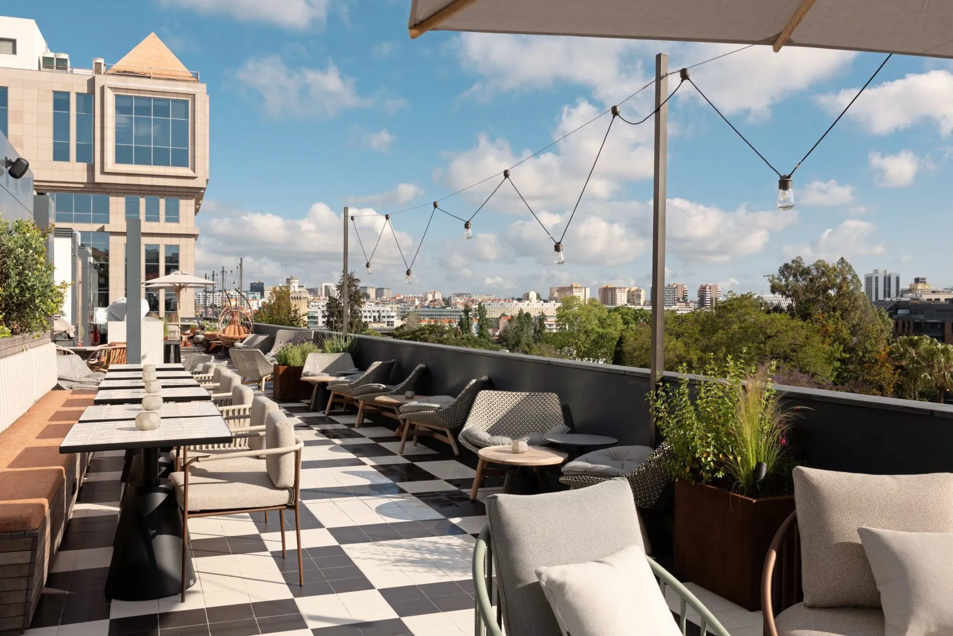 Die Rooftop-Bar im fünften Stock kombiniert klassische Schachbrettfliesen mit modernem Outdoor-Mobiliar und bietet einen weiten Blick über Lissabons Dächer.