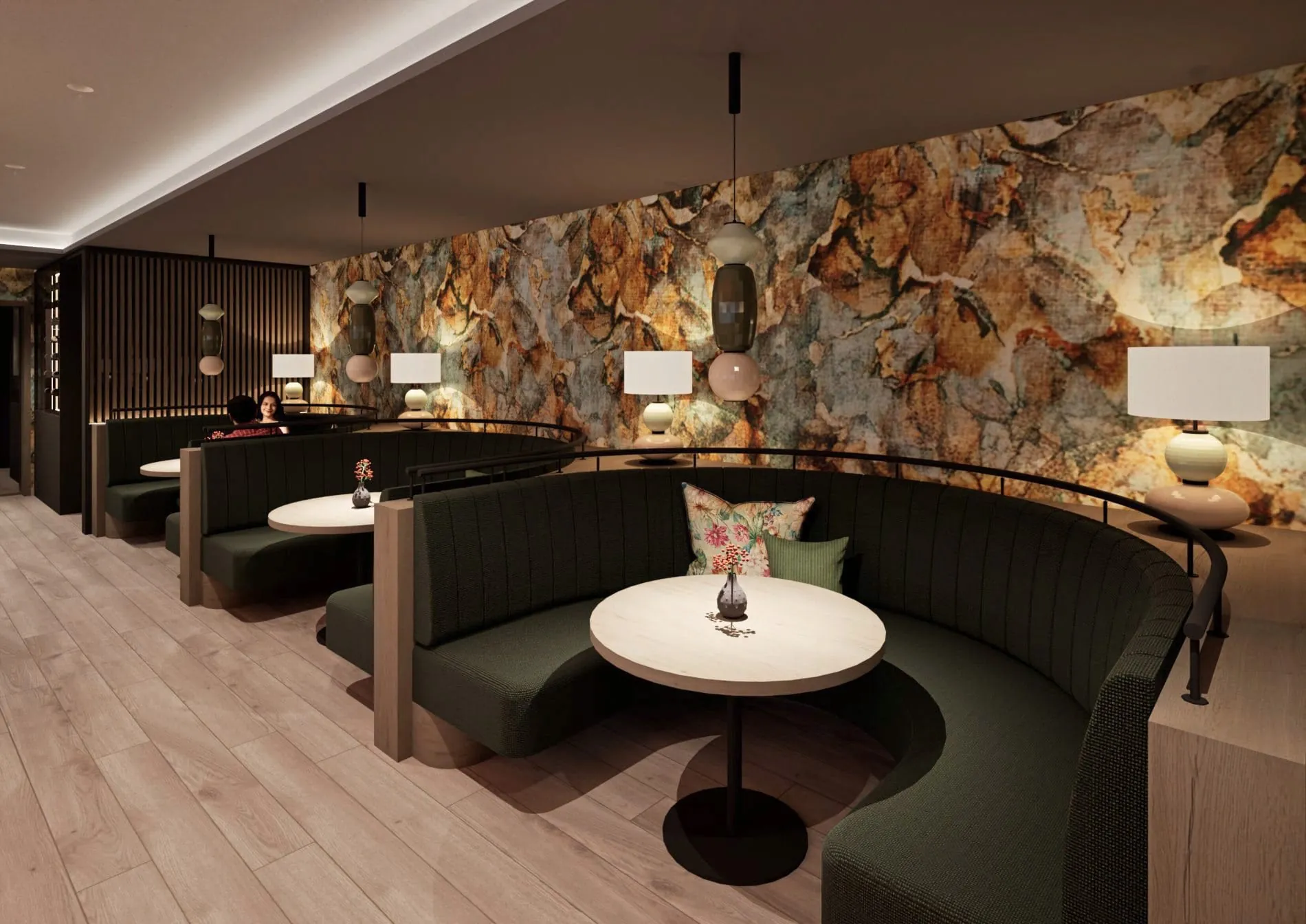 Halbrunde Sitznischen vor einer steinartigen Wandgrafik schaffen im Restaurant private Rückzugsorte.