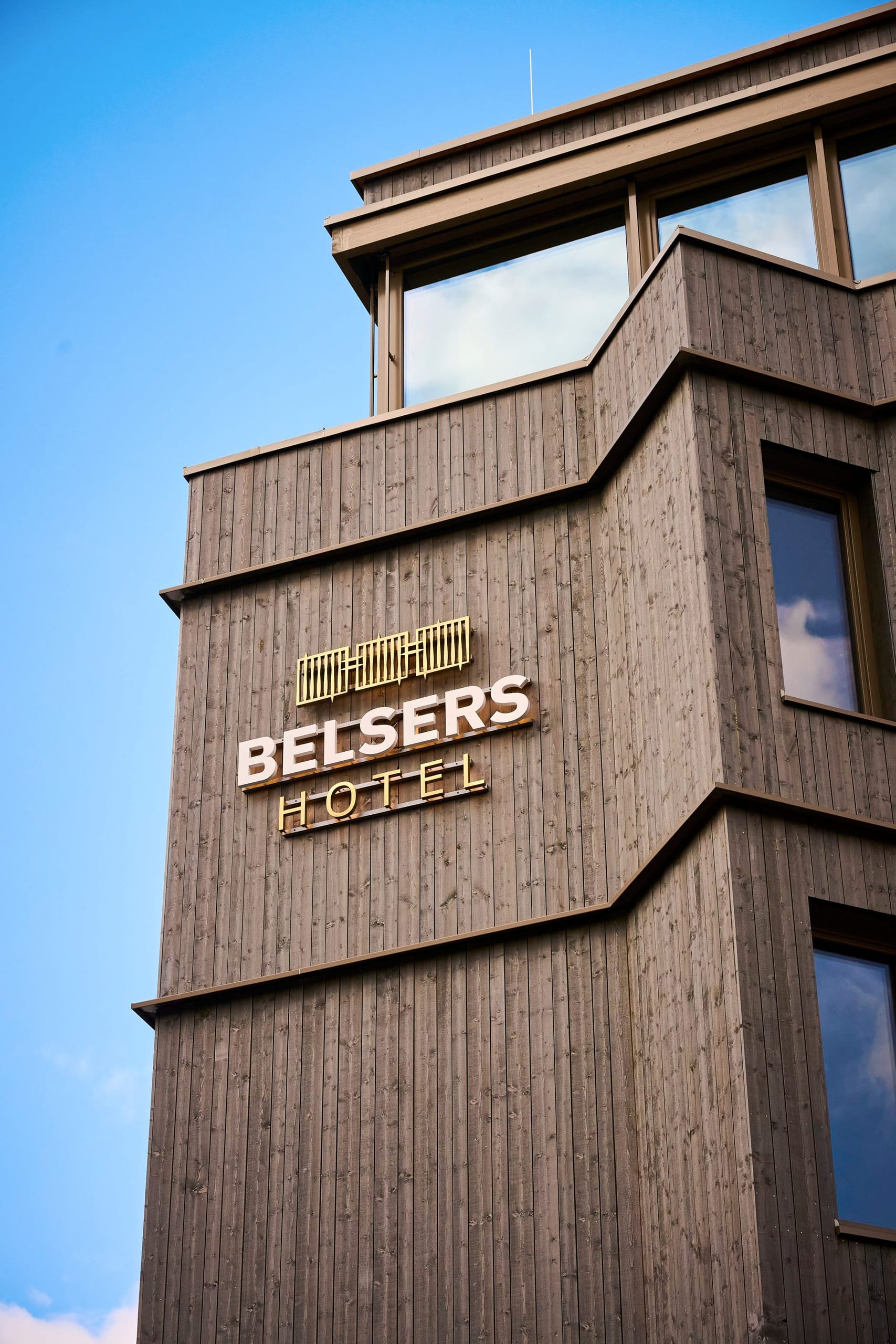 Die vier Gebäude erhielten eine Fassade aus dunklem Lärchenholz, das mit einem Vorvergrauungslack behandelt wurde.