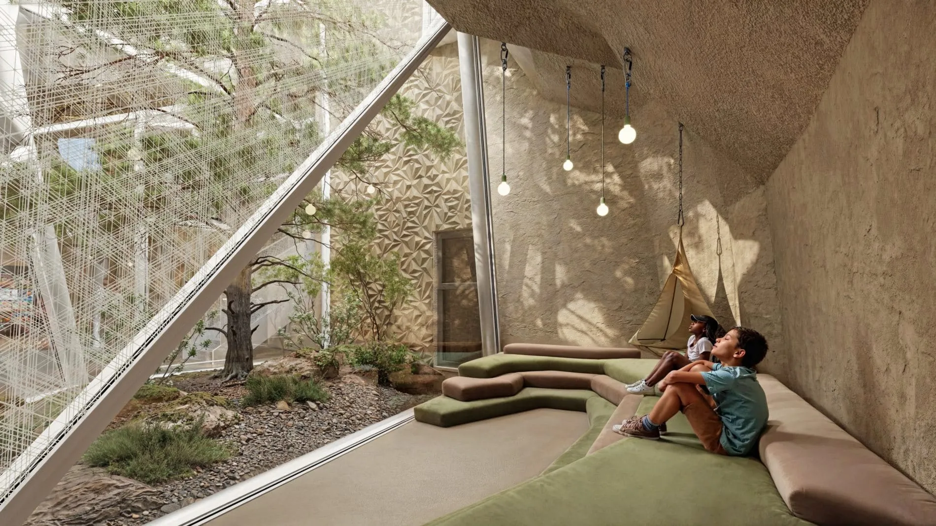 Ein begrünter Patio bringt Tageslicht in die unterirdischen Rückzugsräume. Die geschwungene Sitzlandschaft und die geometrische Wandstruktur unterstreichen das Höhlenkonzept des Studio Noa.
