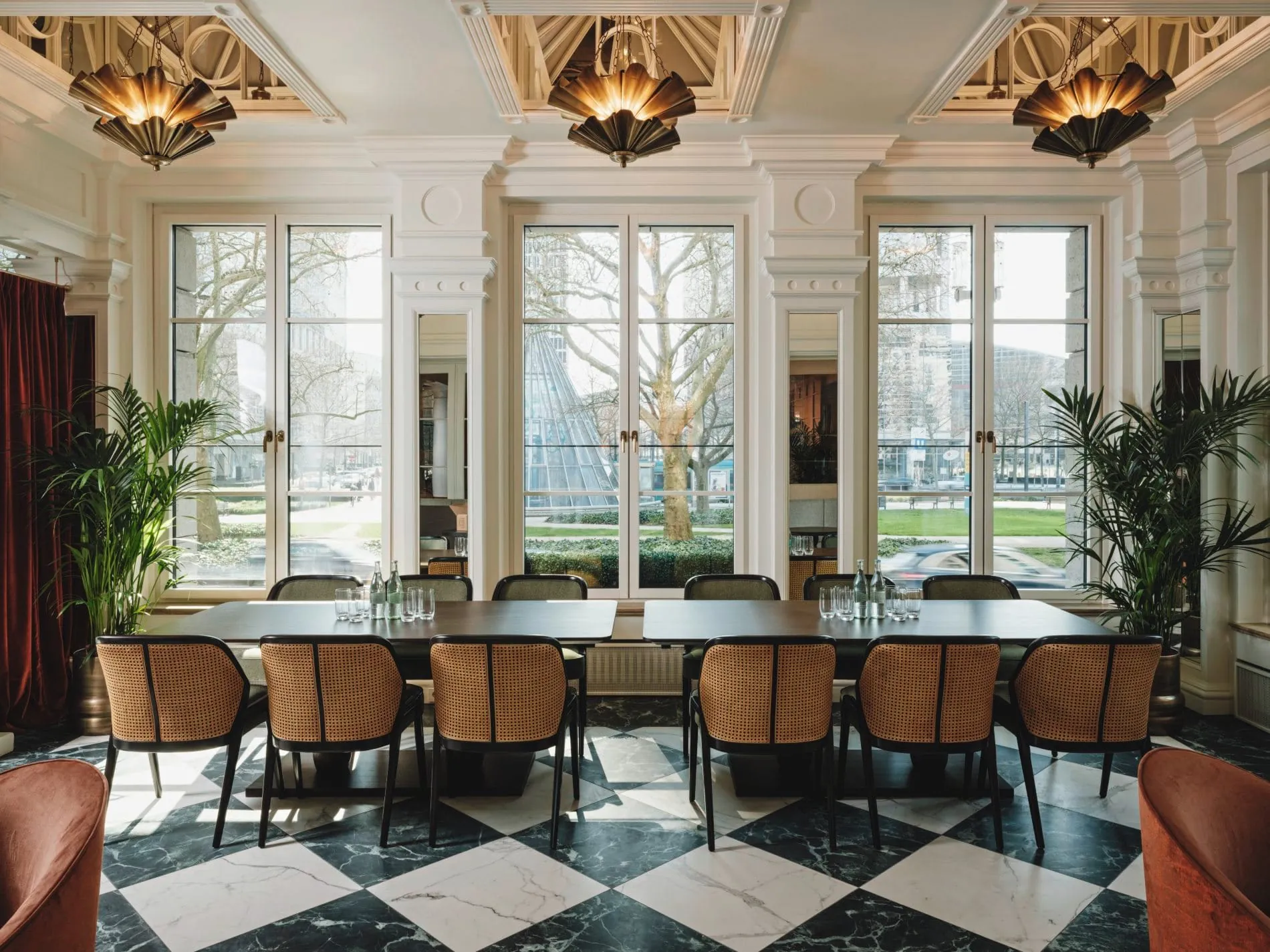 Großzügige Fensterfronten mit Blick auf den angrenzenden Park und ein markanter Schachbrettboden aus Marmor prägen die Lobby-Bar im Taj Hessischer Hof Frankfurt.