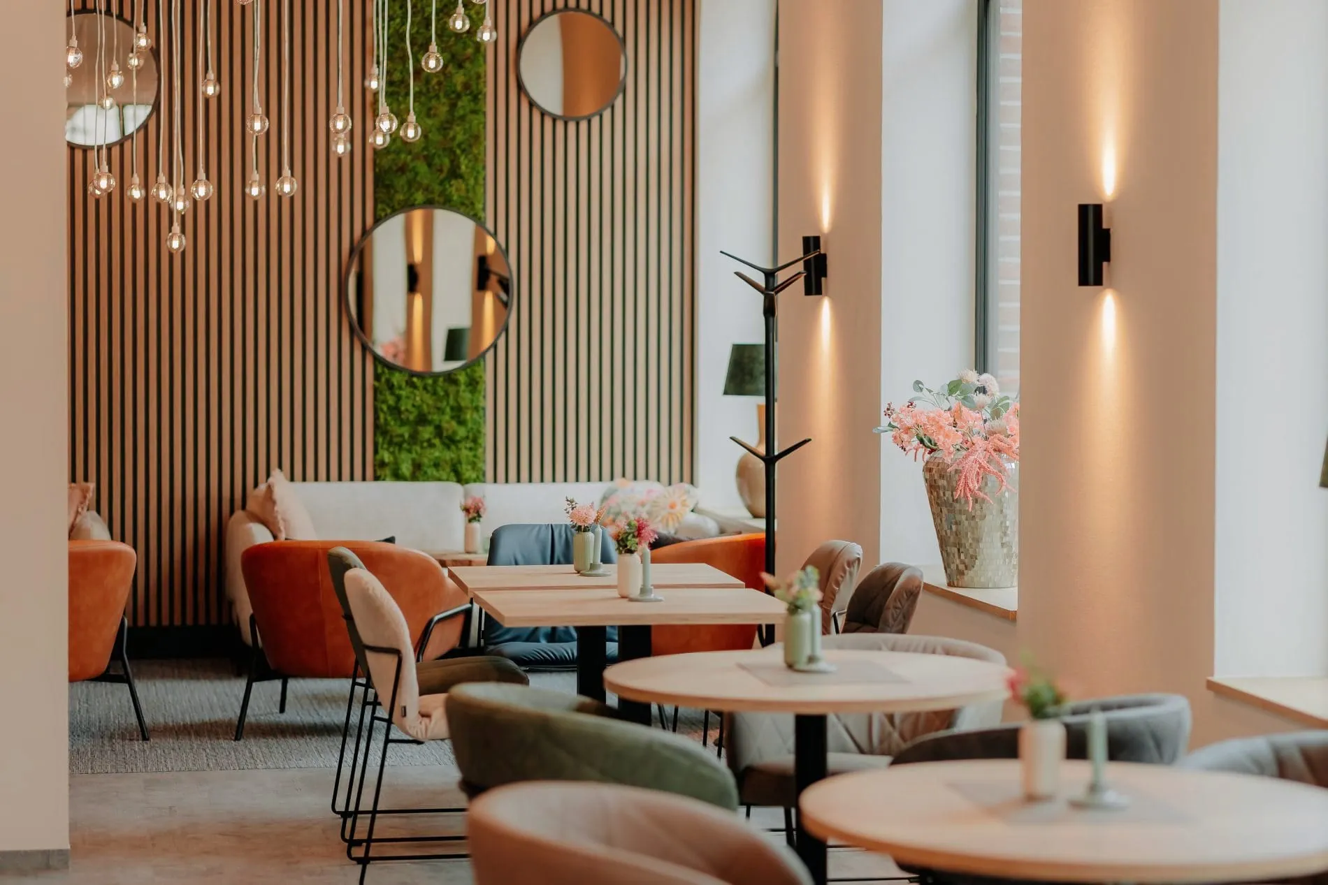 Urbanes Ambiente mit floralen Akzenten: Die Lobby im Hotel Stadthöfe by Hackmann in Rhede.
