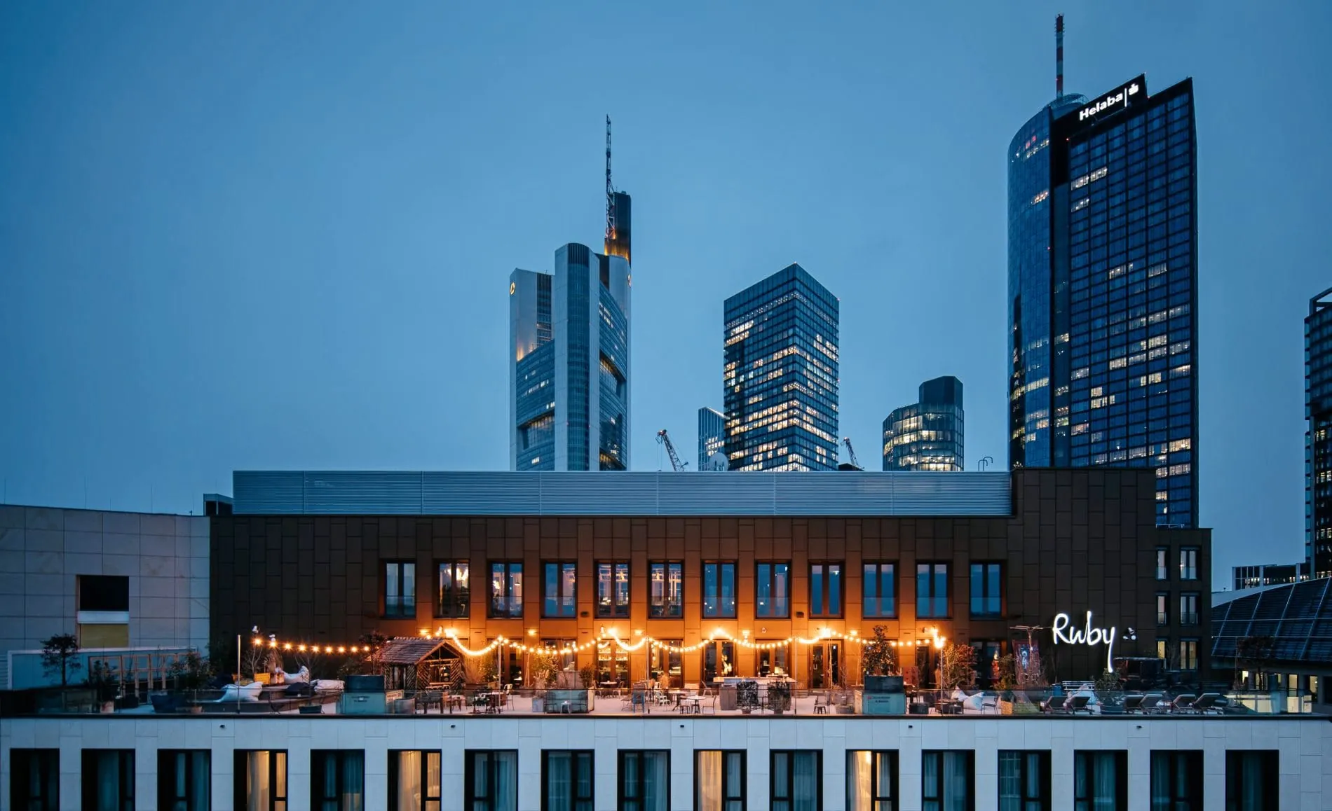 Von der Terrasse des Ruby Louise in Frankfurt genießen Gäste bei einem Sundowner den Blick auf die Skyline.