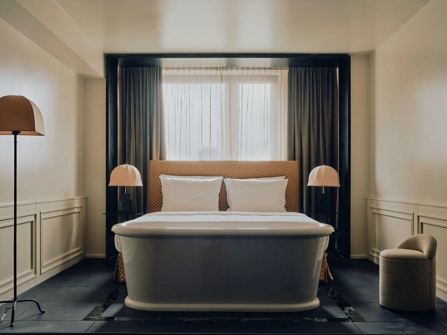 Ein besonderes Highlight der Junior Suite ist die freistehende Badewanne, die offen im Raum direkt vor dem Doppelbett platziert ist.