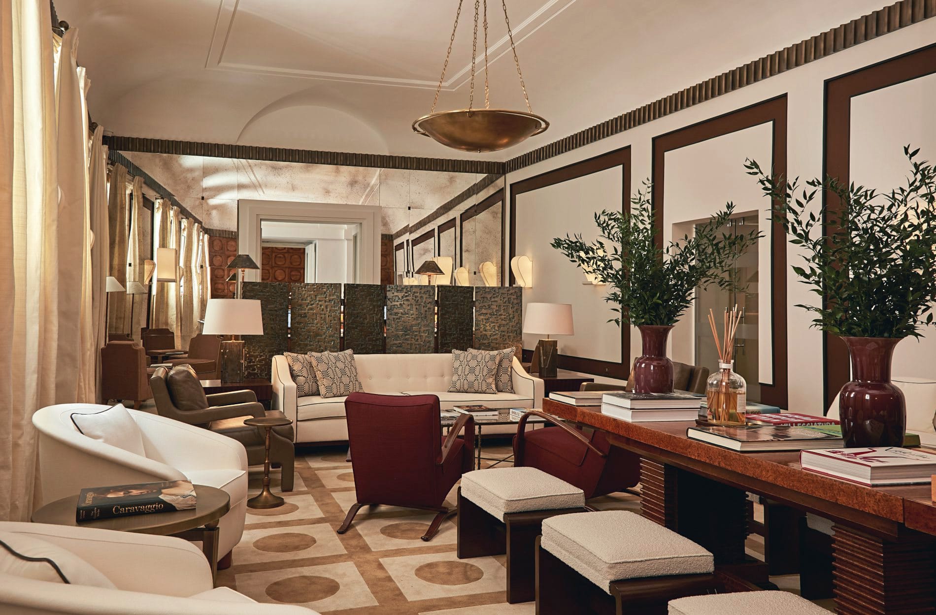 Die Lounge-Ecke im Hotel de Russie zeichnet sich durch ein harmonisches Farbspiel aus gedecktem Rot, Creme und tiefen Brauntönen aus.