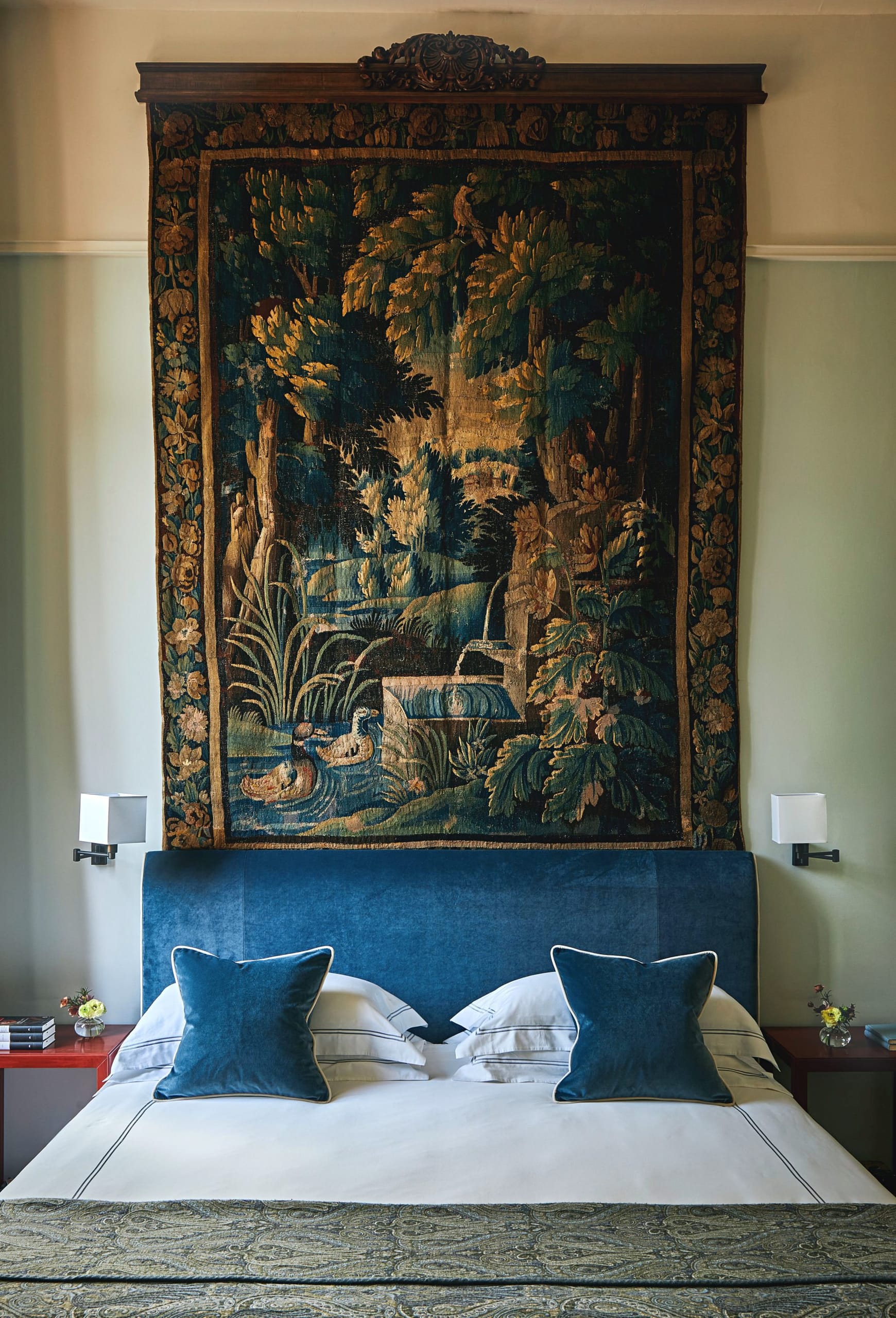 Ein großformatiger, historischer Bildteppich über dem tiefblauen Samtbett dient als kunstvoller Blickfang im Schlafzimmer der Repubblica Suite.