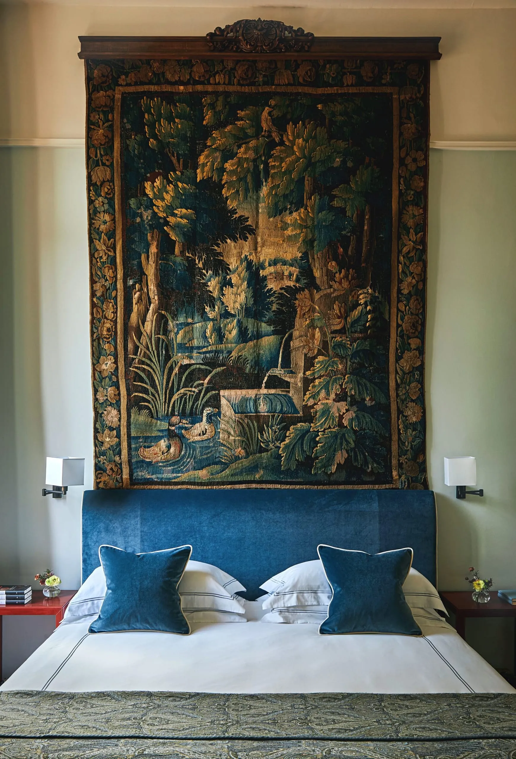 Ein großformatiger, historischer Bildteppich über dem tiefblauen Samtbett dient als kunstvoller Blickfang im Schlafzimmer der Repubblica Suite.