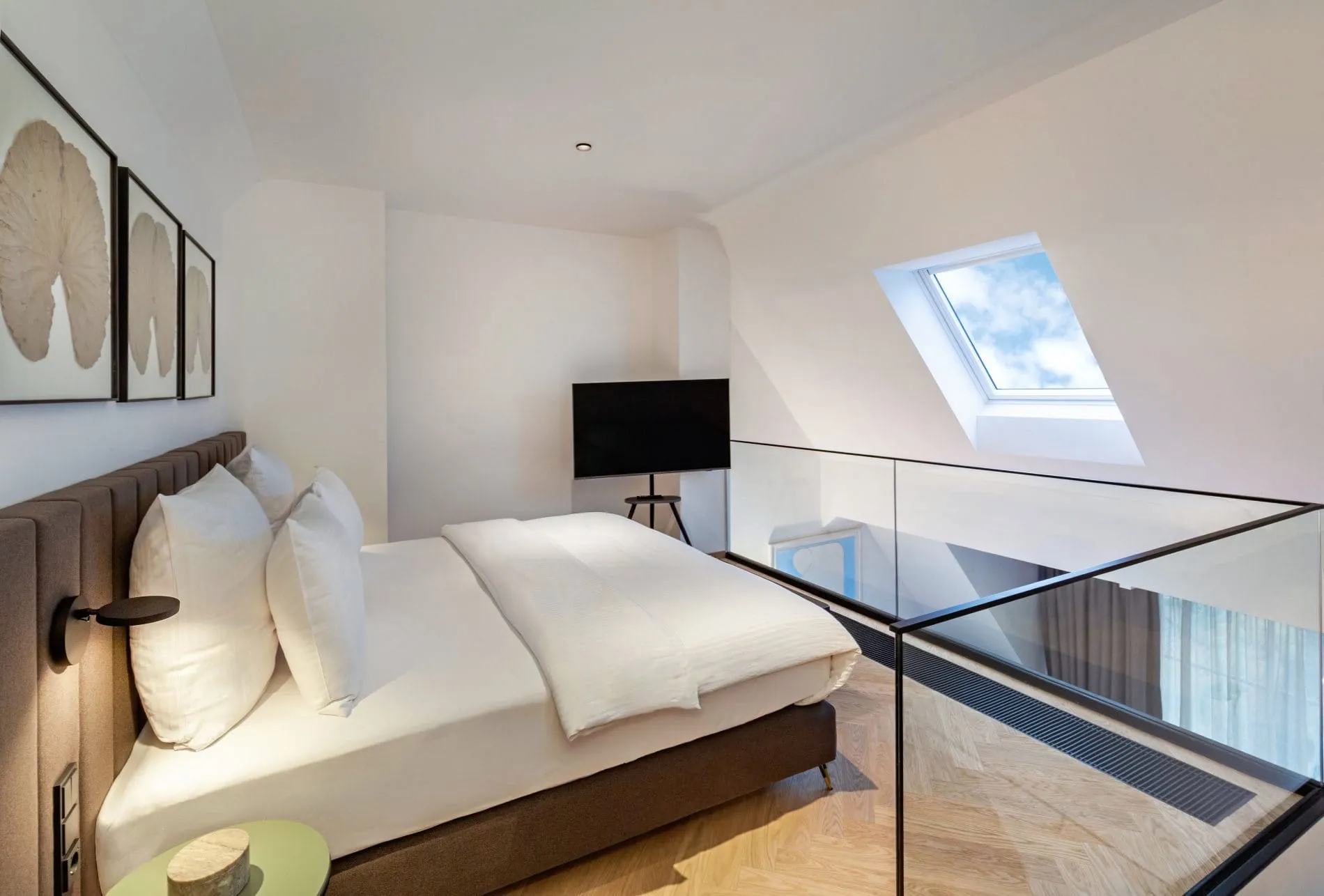 Der Schlafbereich auf der Galerie der Deluxe-Suite bietet durch das Dachfenster einen freien Blick in den Himmel. Das offene Raumkonzept verbindet Schlaf- und Wohnbereich.