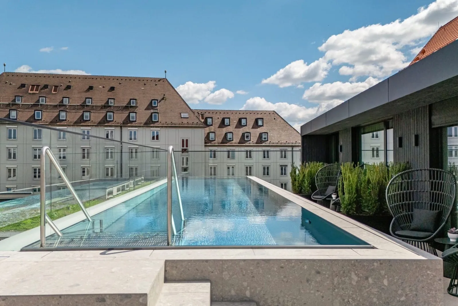 Der 14 Meter lange, ganzjährig beheizte Rooftop-Pool bietet Hotelgästen exklusiven Badespaß über den Dächern von Augsburg.