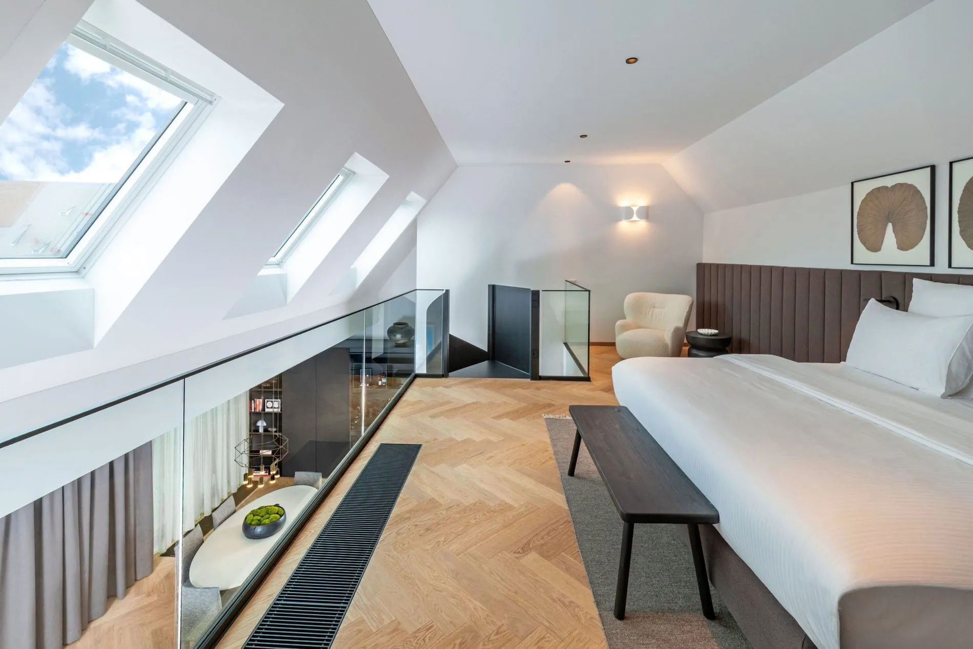 Auf der Galerie der Signature-Suite befindet sich ein großzügiges Doppelbett. Mehrere Dachfenster sorgen für eine helle und angenehme Atmosphäre. Von der Galerie aus eröffnet sich der Blick auf den Essbereich.