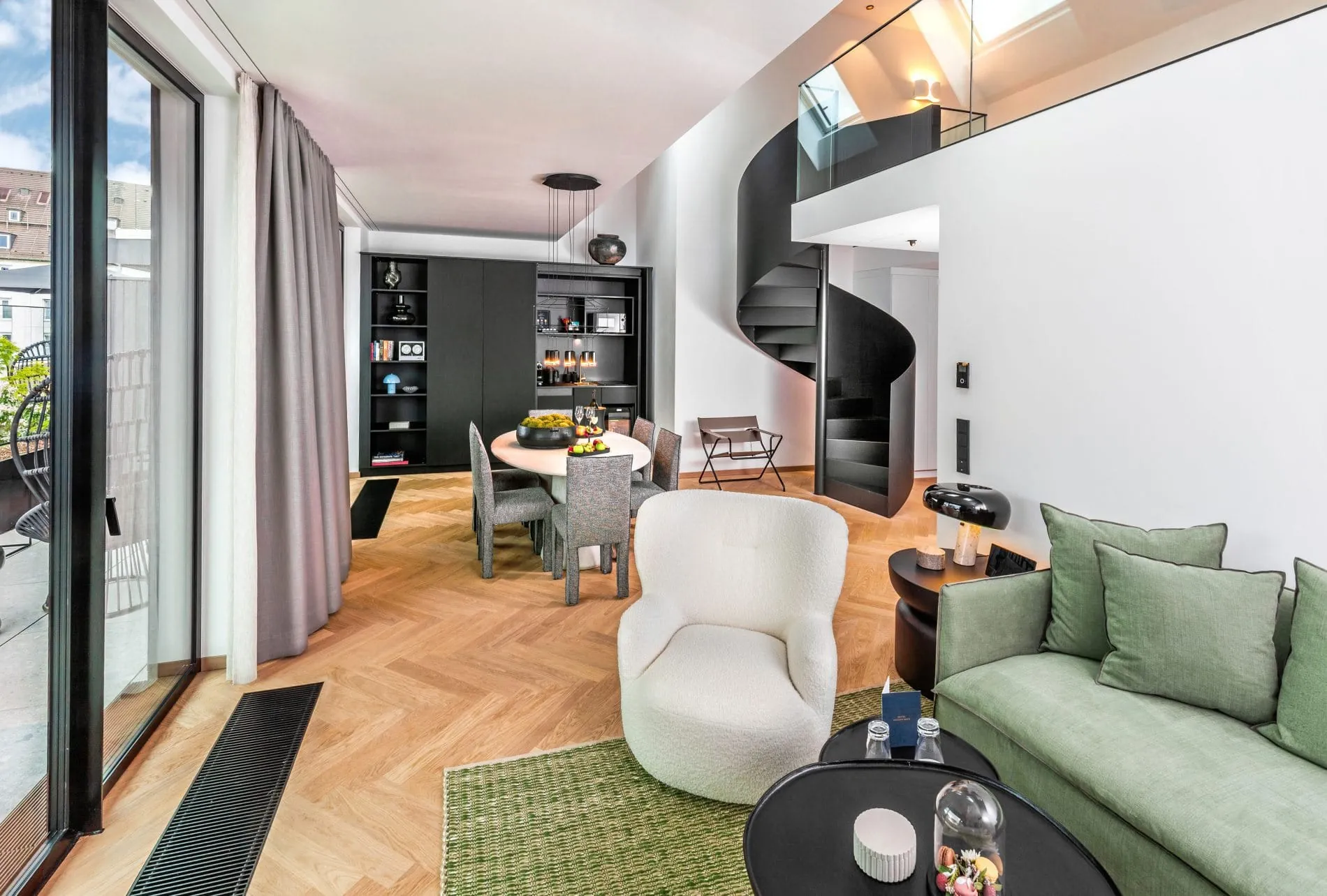 Die Signature-Suite verfügt über ein helles, offen gestaltetes Wohnkonzept mit einer Wendeltreppe zur Galerie. Bodentiefe Fenster verbinden den Wohnbereich mit der privaten Terrasse.
