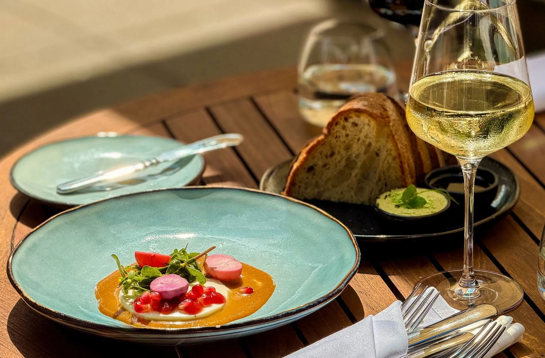 Aus dem aktuellen Saison-Menü der Elbuferei: Cremige Buttermilch-Panna Cotta mit Granatapfel, Radieschen und würzigem Miso, verfeinert mit Portulak.