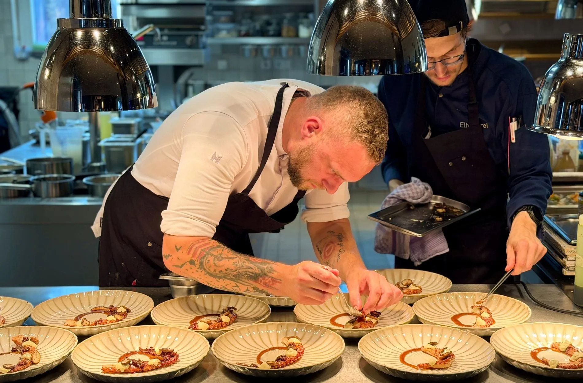 Küchenchef David Schöbel bei Anrichten des sommerlichen Pulpo-Gangs aus dem neuen Menü-Konzept "Saisonale Strömung".
