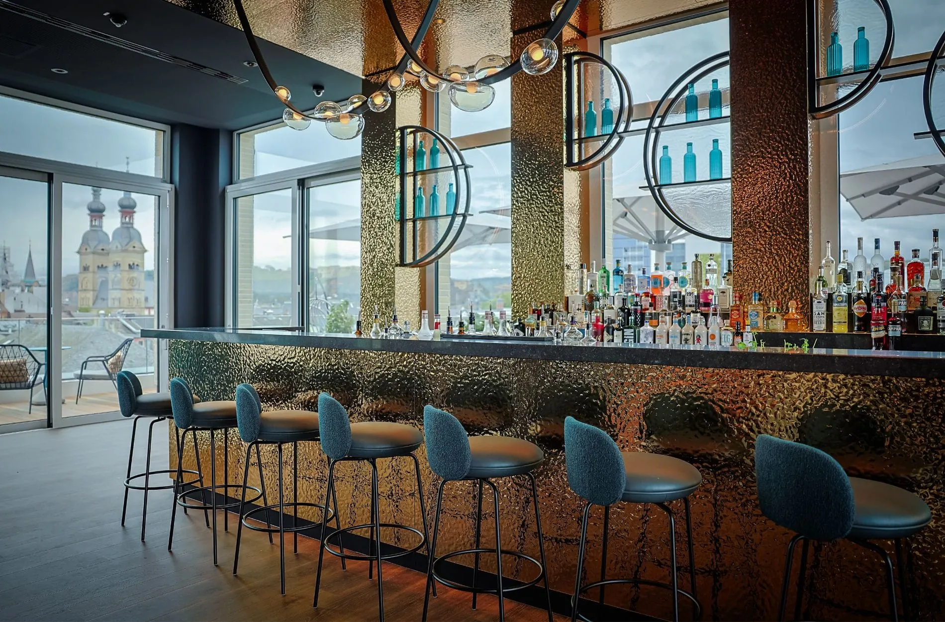 Die Rooftop One Bar: Der freistehende Bartresen ist unmittelbar vor der großzügigen Fassadenverglasung positioniert.