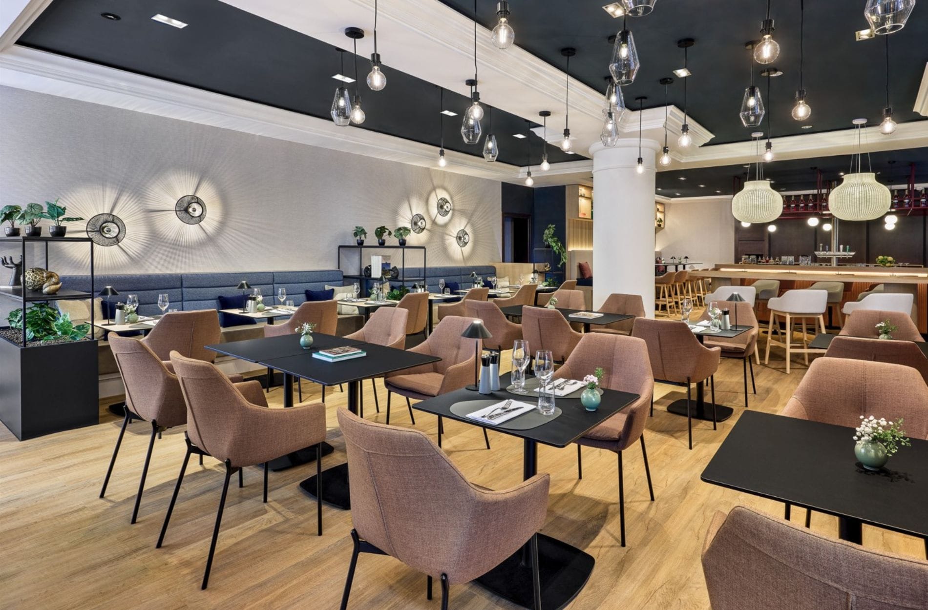 Das wiedereröffnete Restaurant The Local im Leipzig Marriott setzt auf ein modernes Interieur mit hellem Holz, schwarzem Metall und gedeckten Blau-, Braun- und Beigetönen. Unterschiedliche Sitzbereich und ein Bartresen sollen Hotel- und externe Gäste gleichermaßen ansprechen.