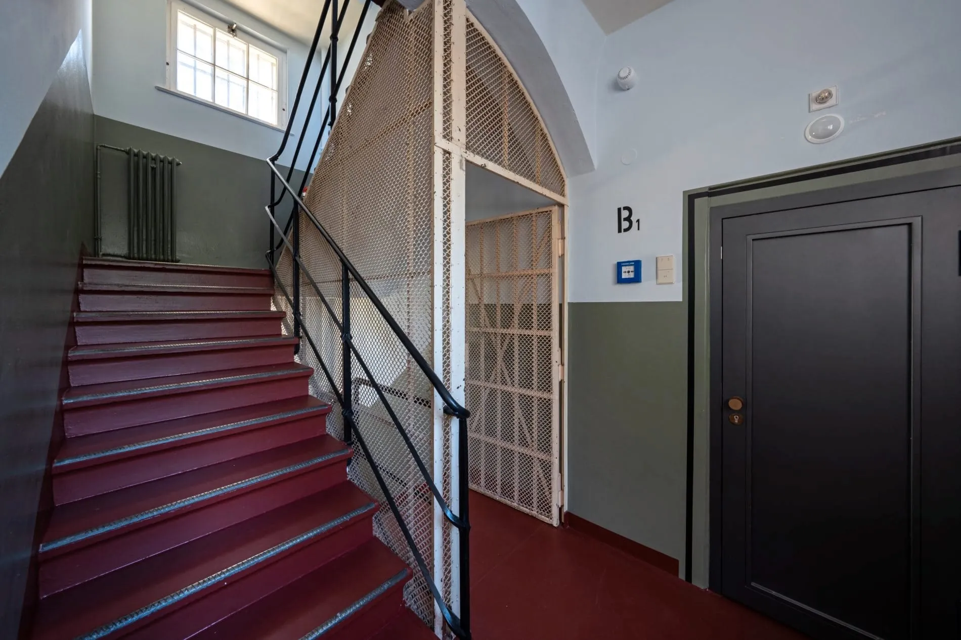 Das restaurierte Treppenhaus mit seinen originalen Schutzgittern bewahrt die authentische Atmosphäre des Baudenkmals.