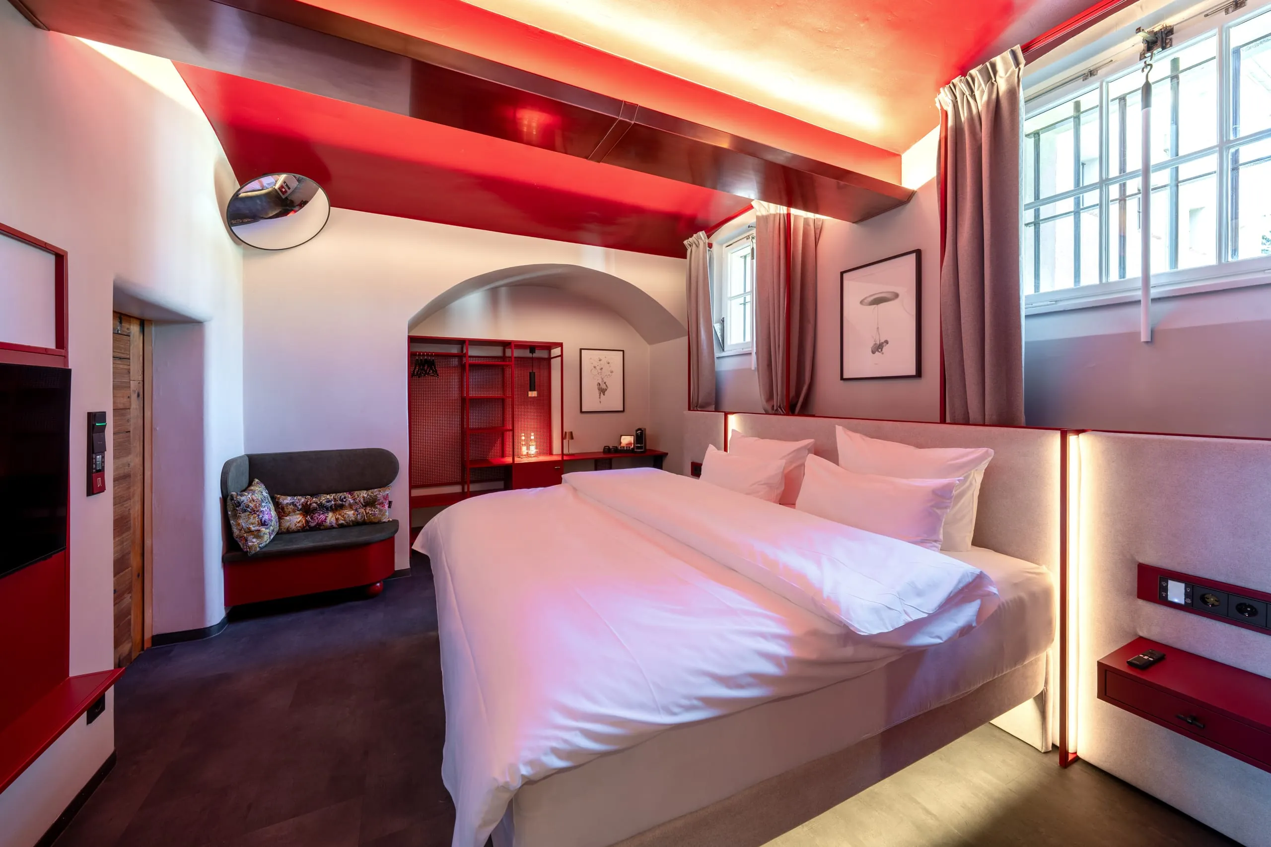 Die neu gestalteten Hotelzimmer verbinden die historische Gefängnisarchitektur mit Boudoir-Charme in kräftigem Weinrot.