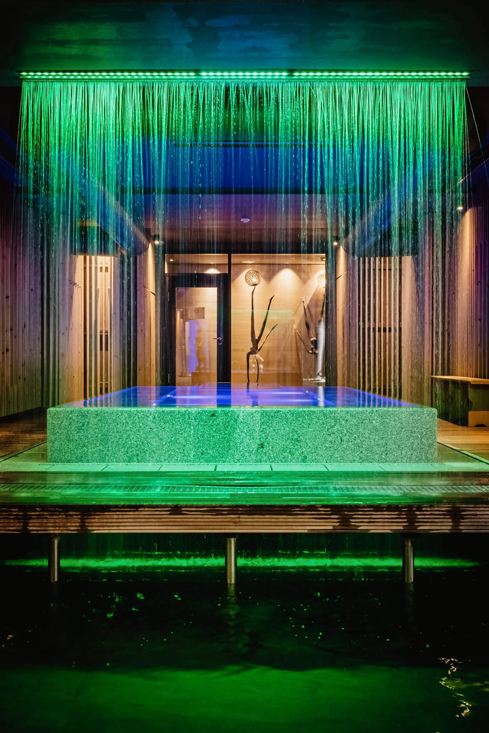 Nach der Sauna geht es zum Cooldown durch einen Regenvorhang in das Kaltwasser-Tauch-becken und wieder zum Aufheizen in den 35 Grad warmen „Naked Rock-Pool“. Dieser ist aus einem einzigen Granitblock gefertigt.