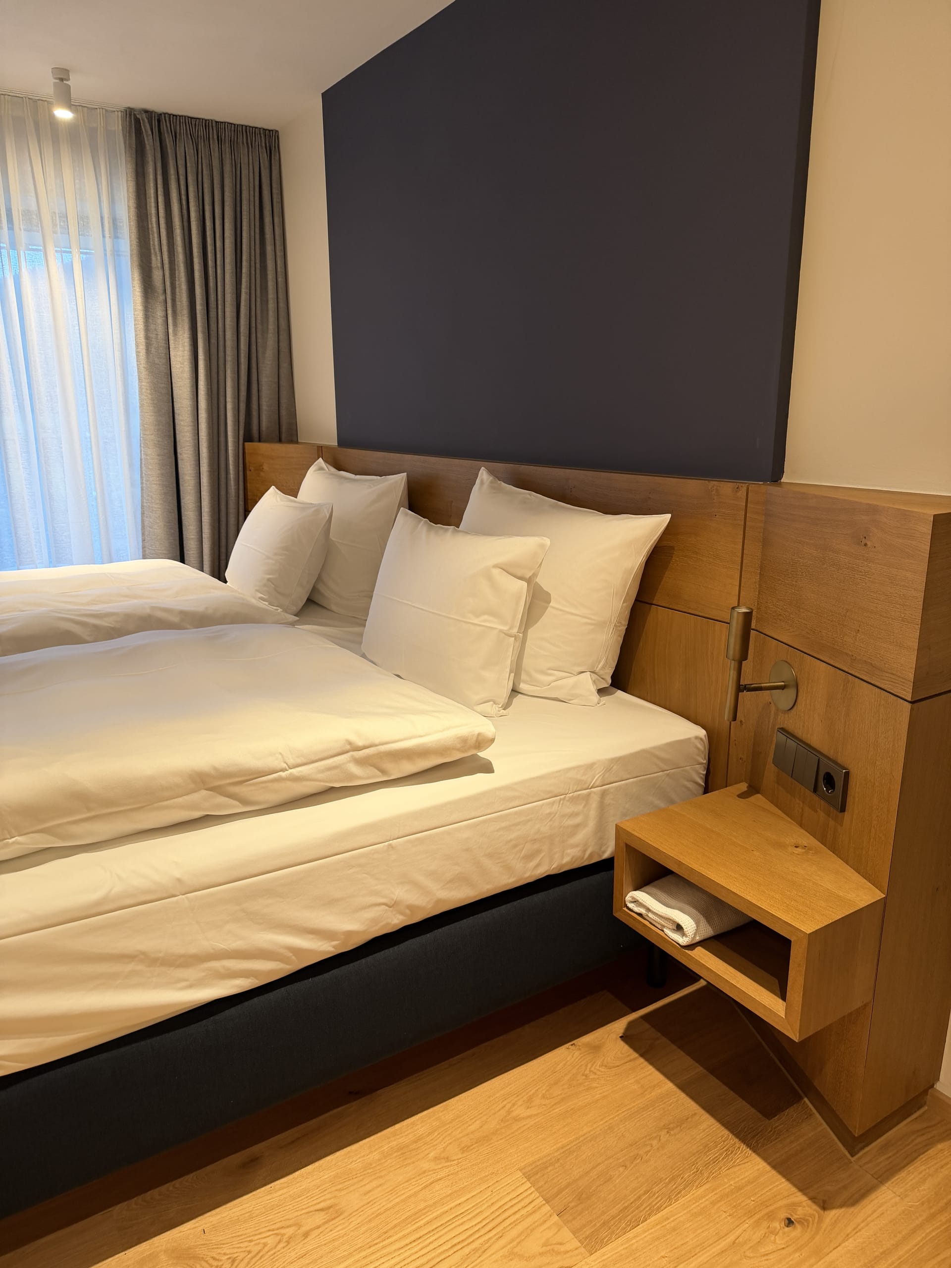Rückzug statt Arbeitsplatz: Im neuen Schlafzimmer sorgen warme Hölzer und ruhige Farben für Wohnlichkeit. Auf einen klassischen Schreibtisch wurde bei der Neugestaltung bewusst verzichtet.