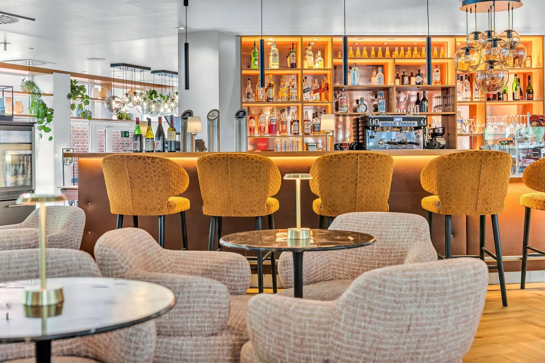 Die neu gestaltete Hotelbar lädt mit Sesseln und warmer Beleuchtung zum Networken oder Entspannen ein.